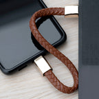 Brown braided USB cable with gold connector on a wooden surface