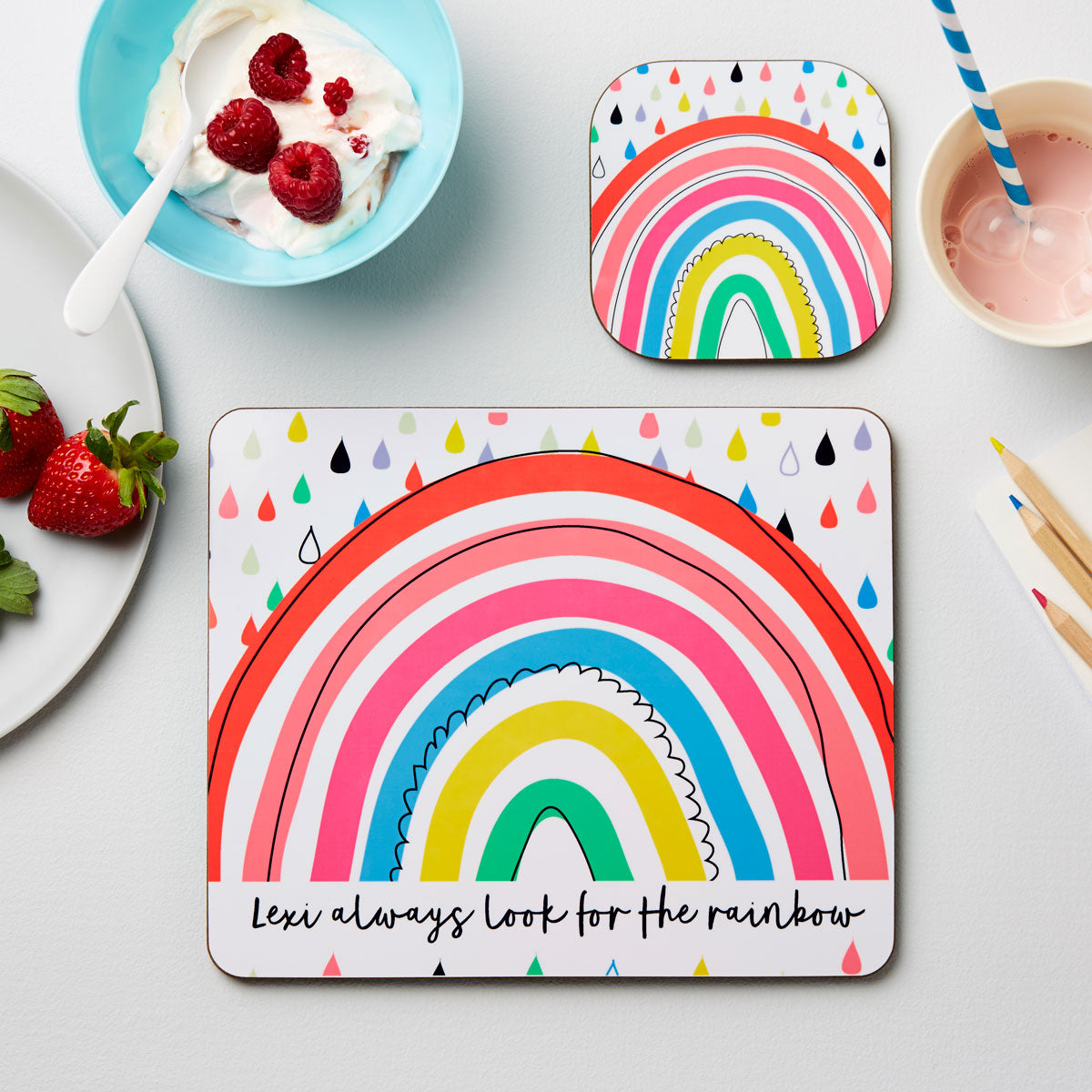 Colorful rainbow-themed placemat on a table with food items.