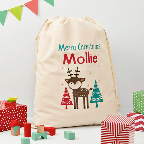 Personalized Christmas sack with reindeer design and text, surrounded by festive presents and decorations.