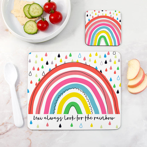 Rainbow-themed placemat with a quote on a table with food and cutlery.