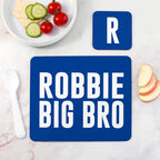 Blue placemat with 'ROBBIE BIG BRO' text on a table with food.