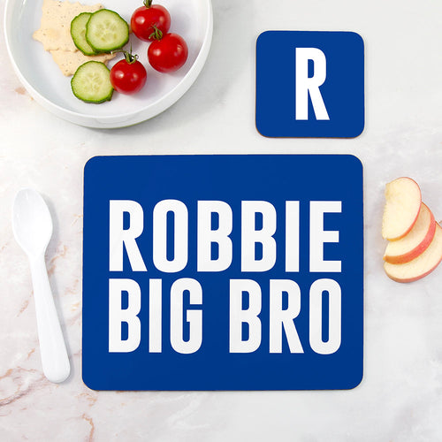 Blue placemat with 'ROBBIE BIG BRO' text on a table with food.