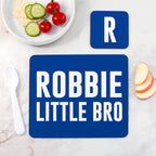 Blue placemat with 'ROBBIE LITTLE BRO' text on a marble surface with food items.