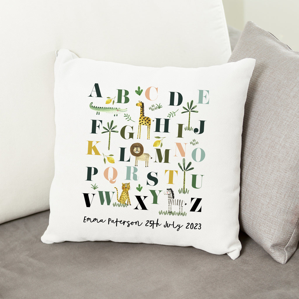 Decorative pillow with alphabet design and personalized text on a couch.