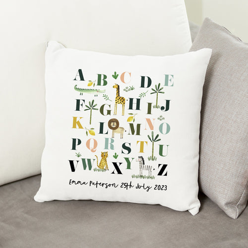 Decorative pillow with alphabet design and personalized text on a couch.