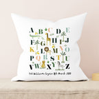 Decorative pillow with alphabet design and personalized text on a beige background