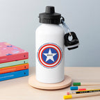 White water bottle with superhero emblem and 'MAX' text on a wooden surface with books and pencils.