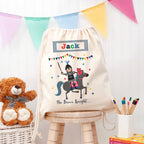 Personalized drawstring bag with a cartoon knight design, teddy bear, and books on a wooden stool.