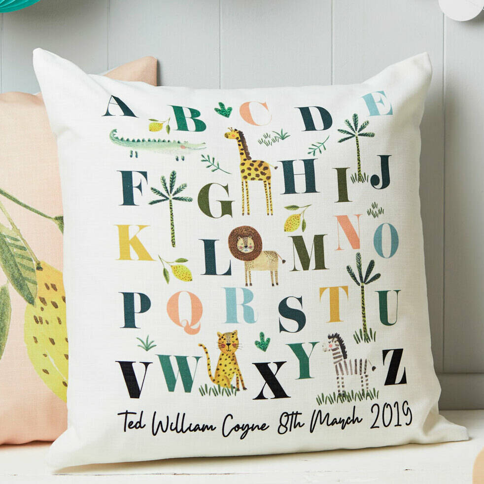 Decorative pillow with alphabet design and animal illustrations on a neutral background