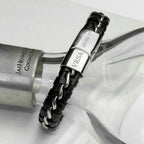Black leather bracelet with silver clasp on a white surface