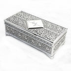 Decorative silver jewelry box with intricate patterns on a white background