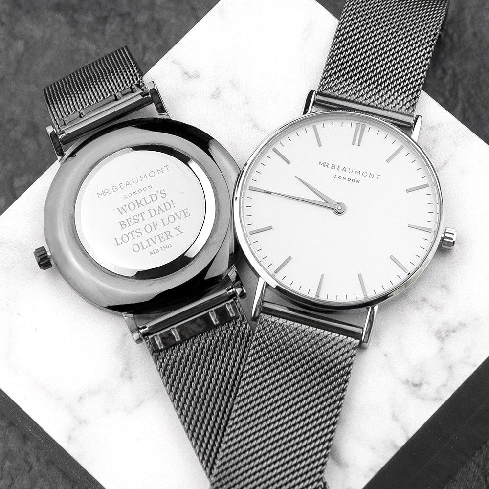 Two watches with mesh straps on a marble surface