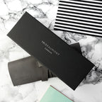 Black MR BEAUMONT LONDON packaging on a marble surface with a black and white striped item.