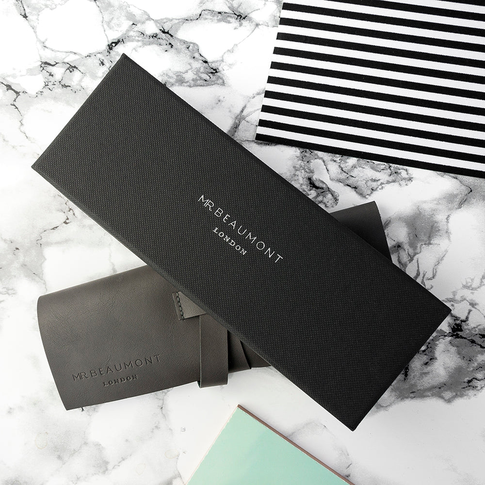 Black MR BEAUMONT LONDON packaging on a marble surface with a black and white striped item.