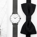 Black watch with mesh band and black bow tie on a white background