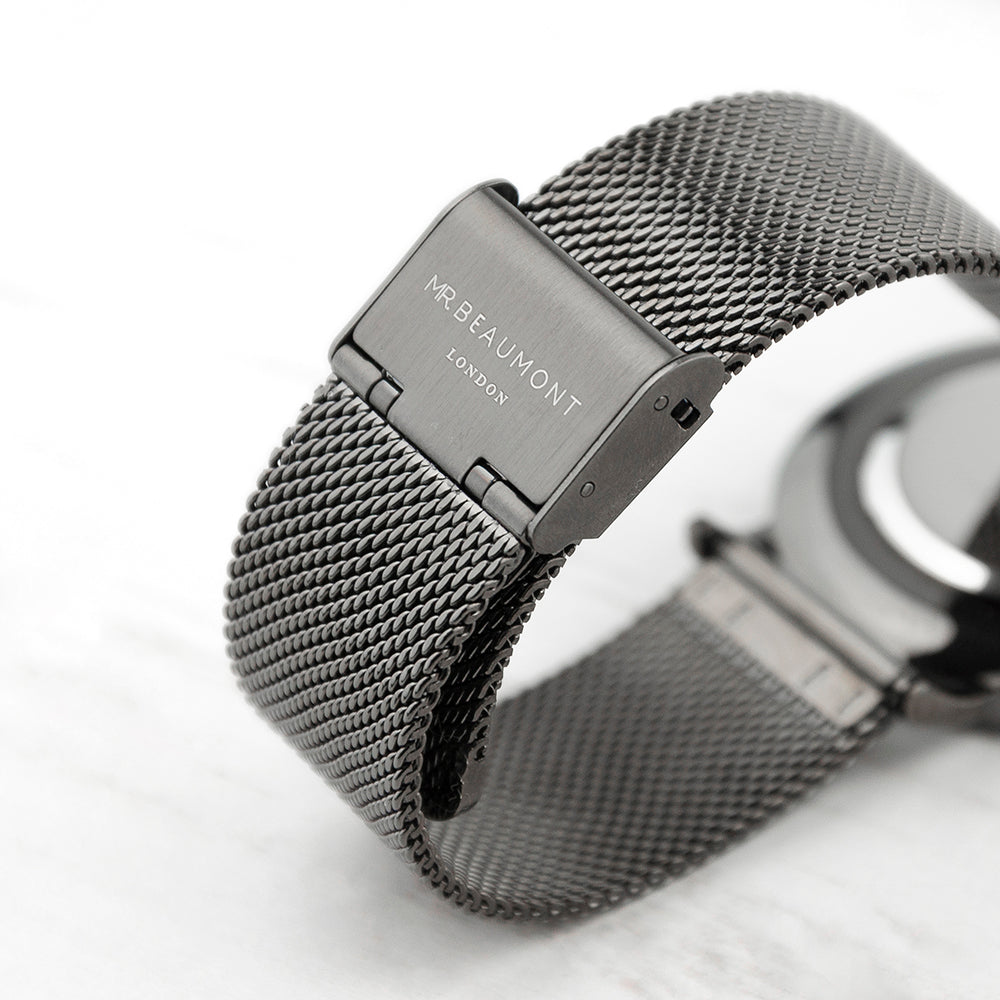 Silver watch with mesh band on a white background, featuring 'Mr Beaumont' branding.