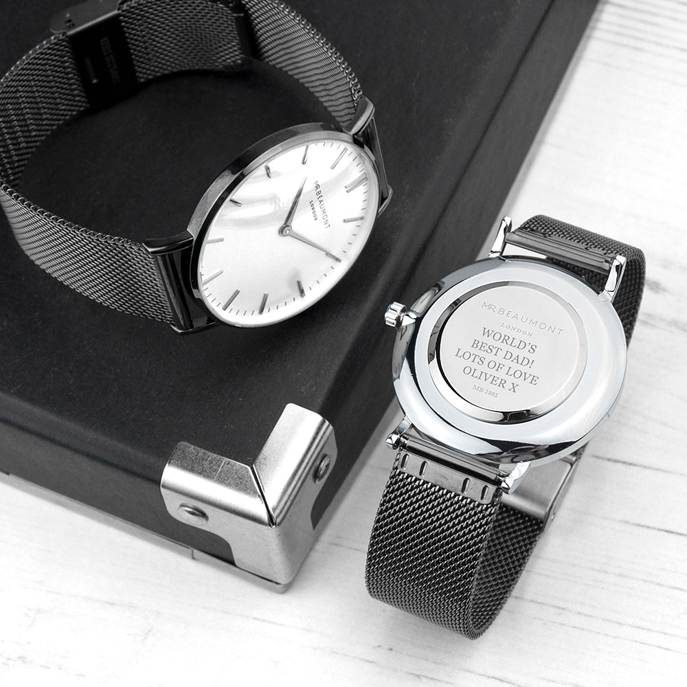 Two watches with mesh bands on a wooden surface
