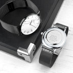 Two watches with mesh bands on a wooden surface