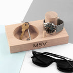 Wooden organizer with keys, watch, and sunglasses on a light surface