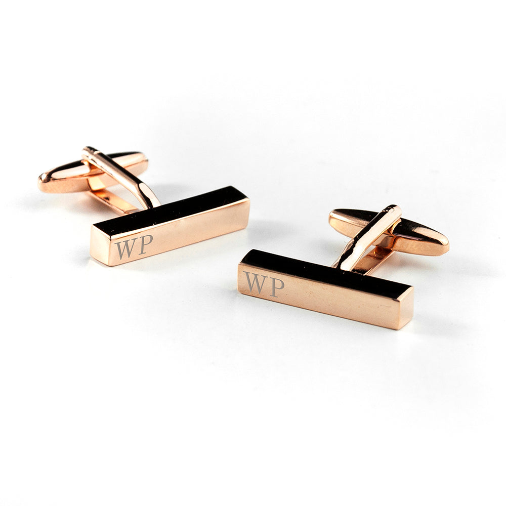 Rose gold and black rectangular cufflinks with initials on a white background
