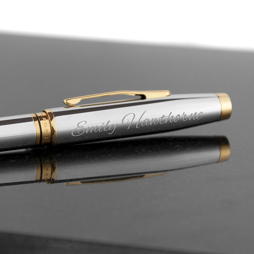Silver pen with gold accents on a reflective surface