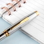 Cross pen with gold accents on a notebook
