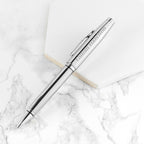 Silver pen with engraved name on a marble surface