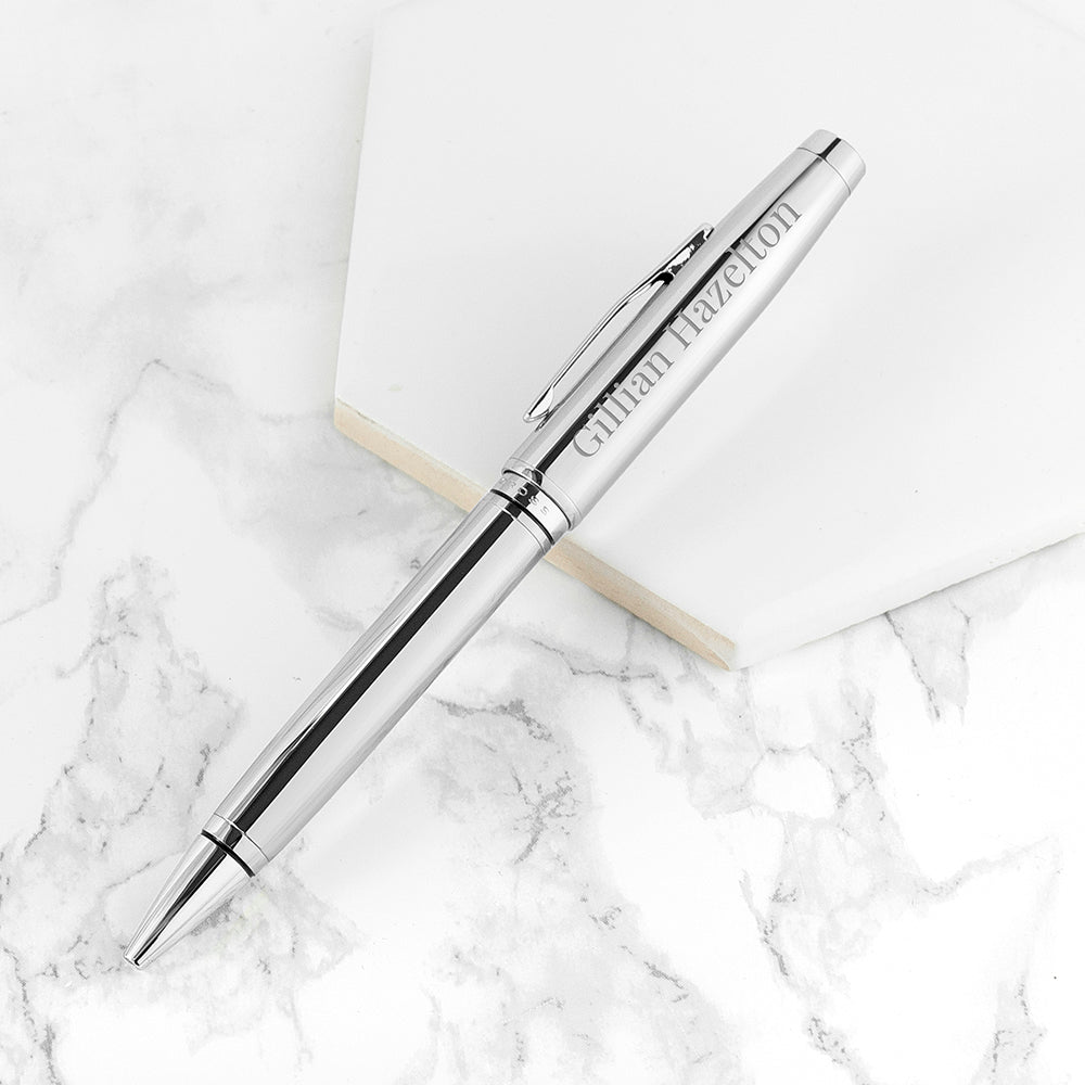 Silver pen with engraved name on a marble surface