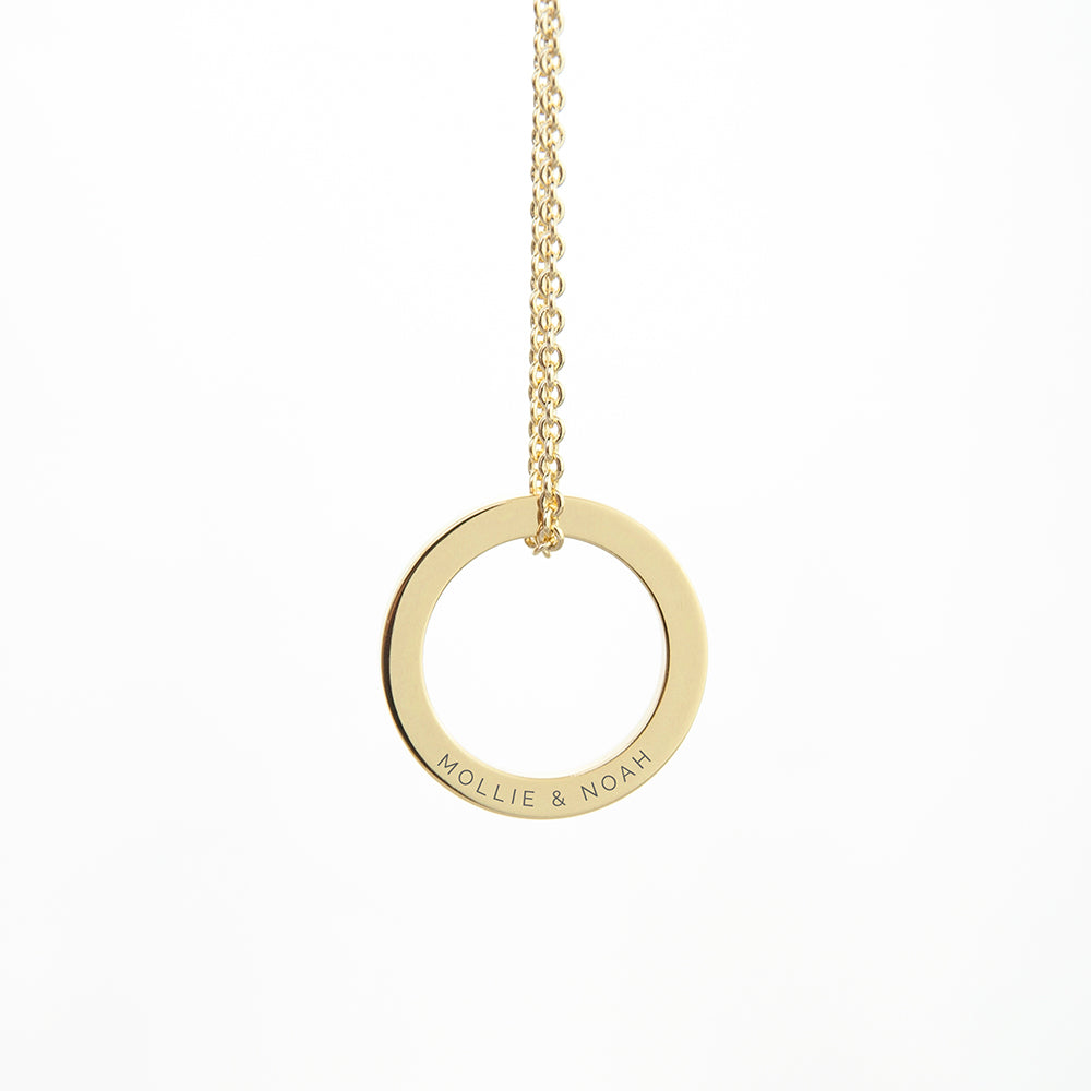 Gold necklace with a circular pendant on a white background