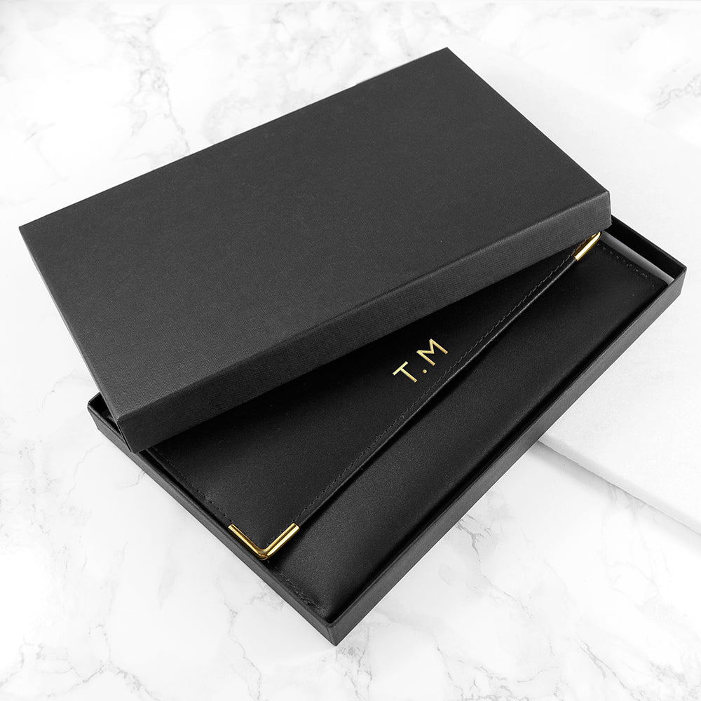 Black box with gold 'T.M' initials on a white marble surface