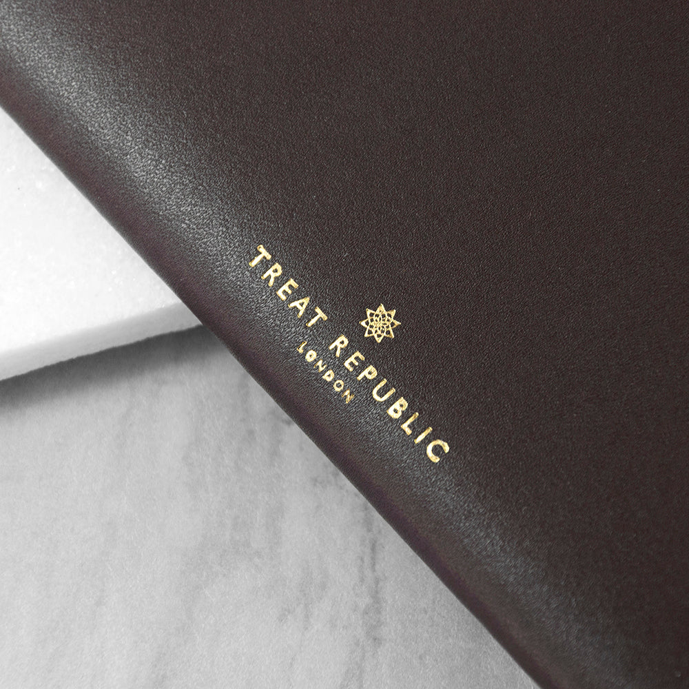 Black leather product with 'Treat Republic London' logo on a gray surface