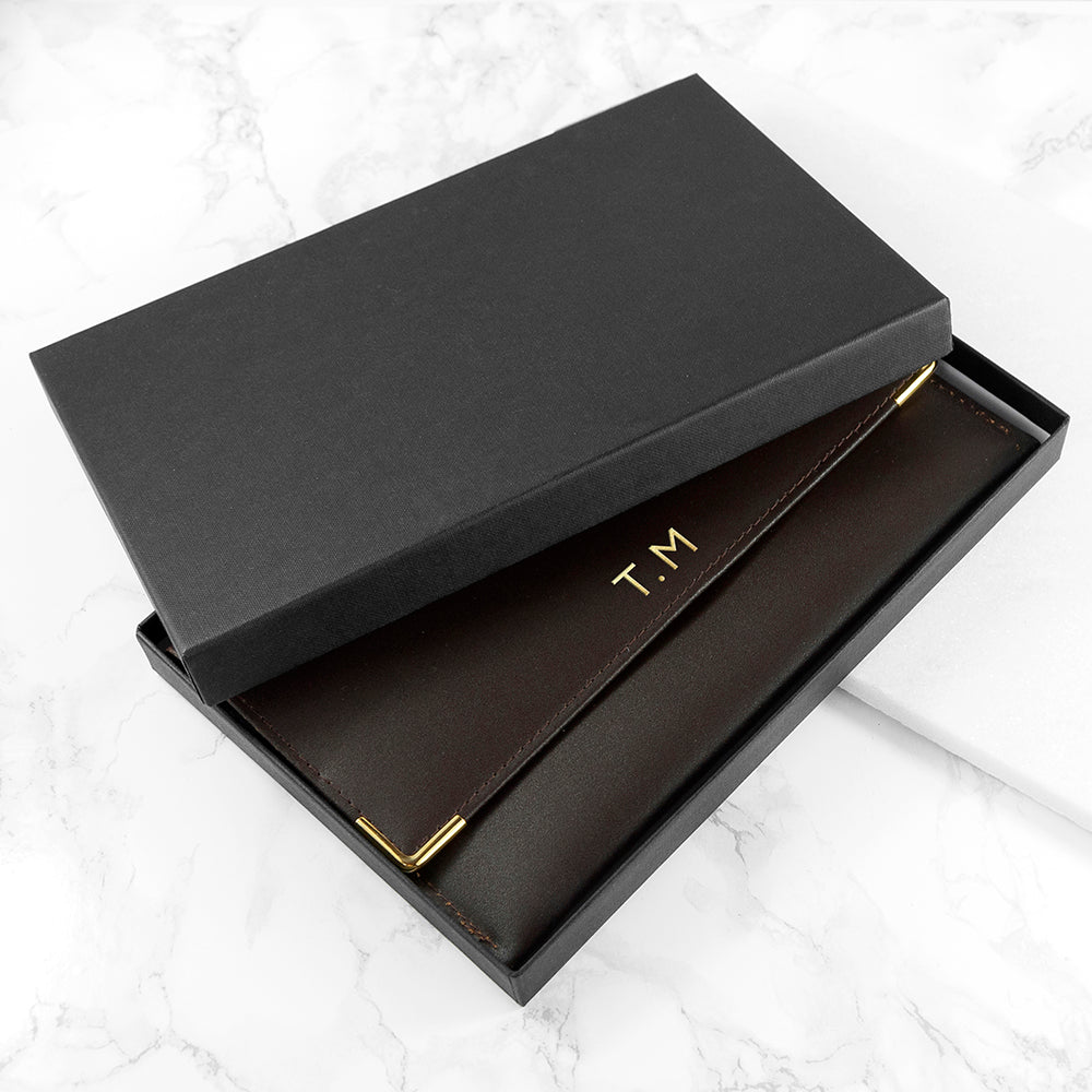 Black box with gold 'T.M' initials on a white marble surface