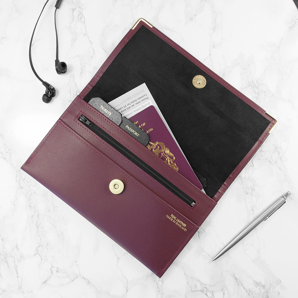 Purple travel wallet with passport and card holder on a white marble surface