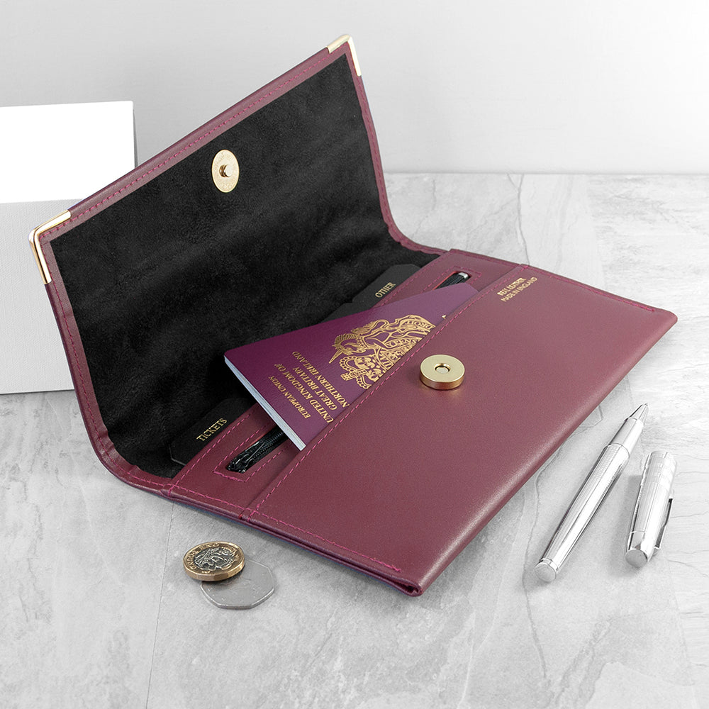 Purple leather wallet with gold accents on a light gray surface