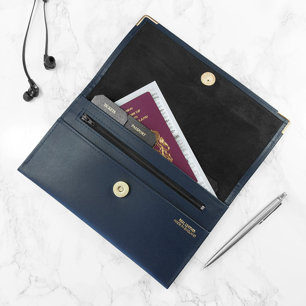 Navy blue travel wallet with passport and cards on a light gray surface