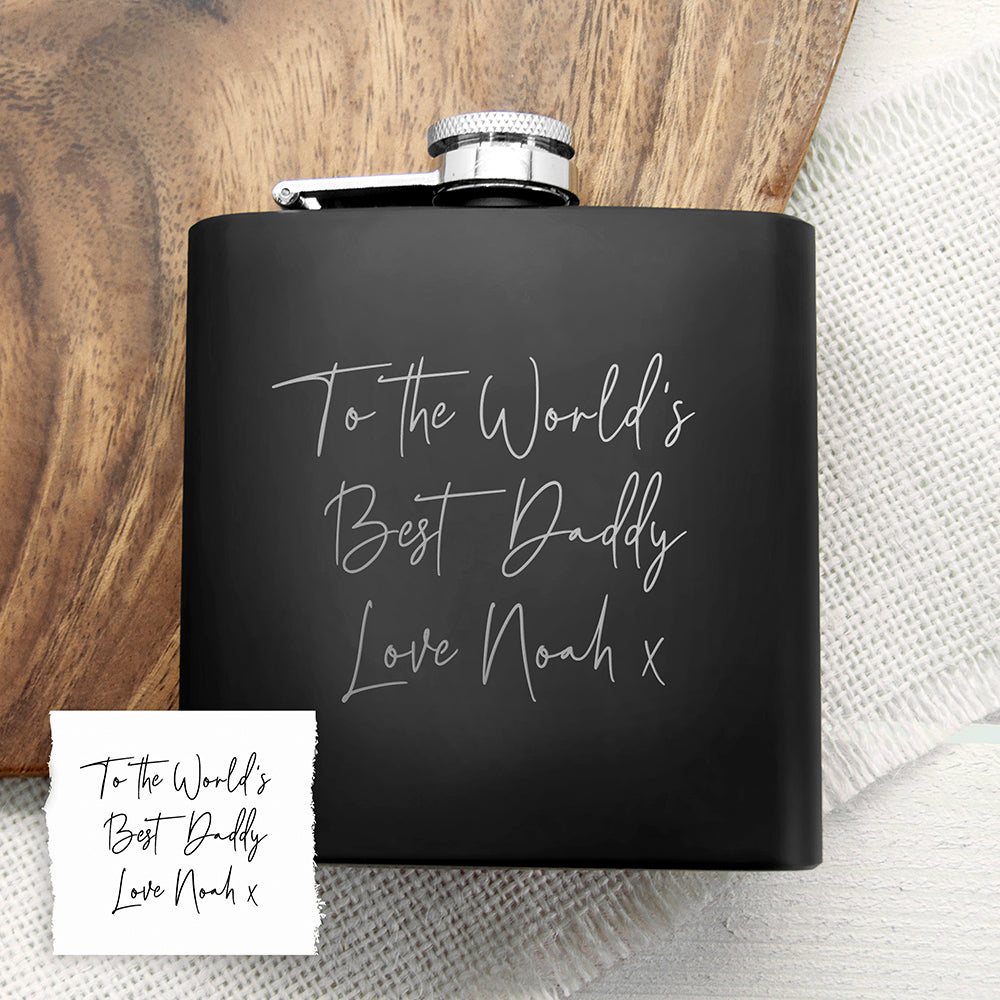 Black flask with engraved message on a wooden surface