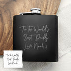 Black flask with engraved message on a wooden surface