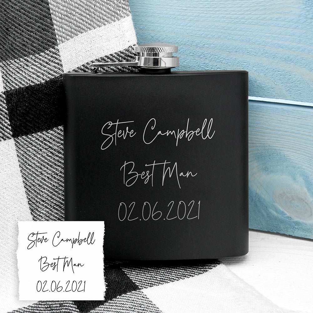 Black flask with engraved text on a checkered fabric background