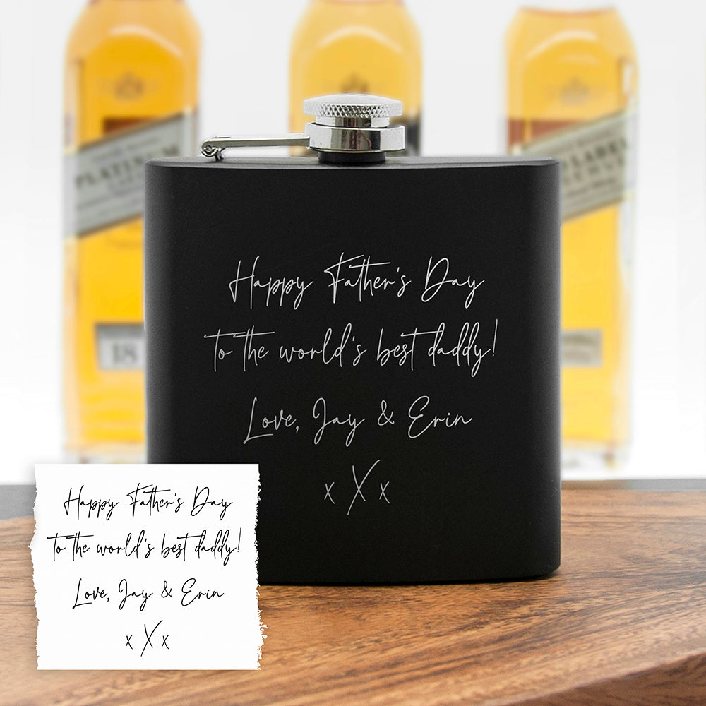 Black flask with personalized message in front of beer bottles