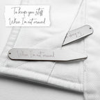 Two silver hair clips with engraved text on a textured white surface.