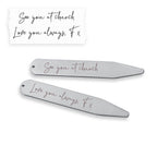 Two metallic hair clips with engraved text on a white background