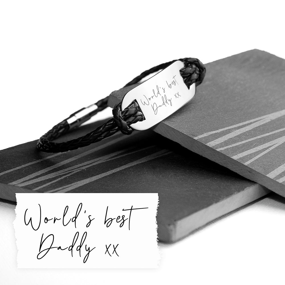 Black braided bracelet with engraved message on a book