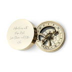 Brass compass with engraved lid on a white background