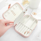 Pink jewelry case with jewelry inside on a white surface