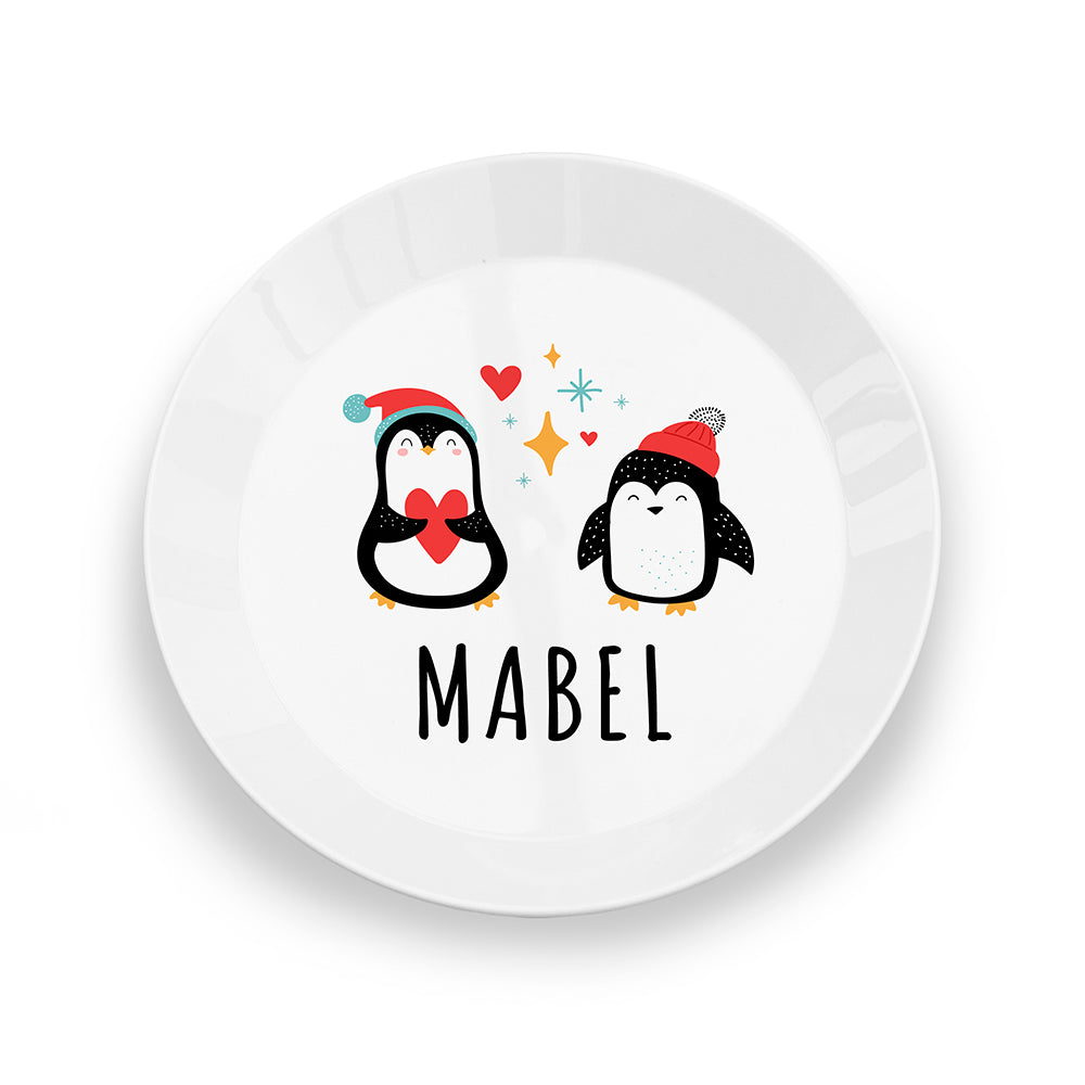 White plate with cartoon penguins and the name 'Mabel' on a white background