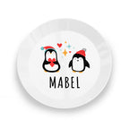 White plate with cartoon penguins and the name 'Mabel' on a white background
