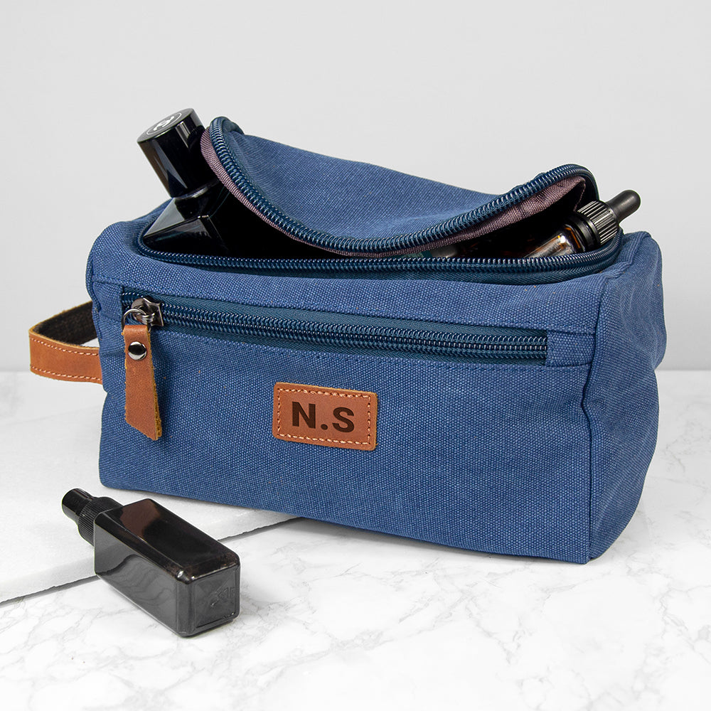 Blue toiletry bag with 'N.S.' label on a white background