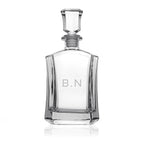 Clear glass decanter with 'B.N' engraving on a white background