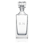 Clear glass decanter with 'B.N' initials on a white background