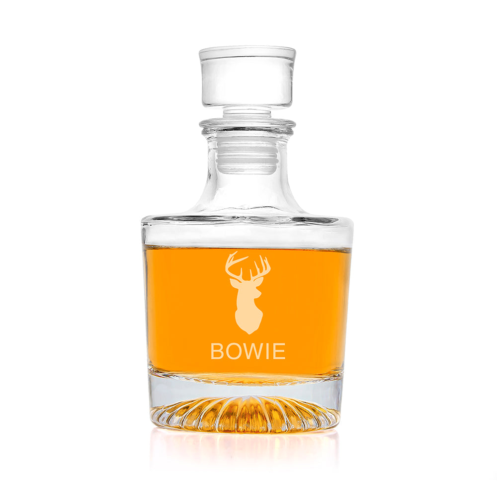 Clear glass decanter with a deer emblem and 'Bowie' engraving, filled with amber liquid on a white background.